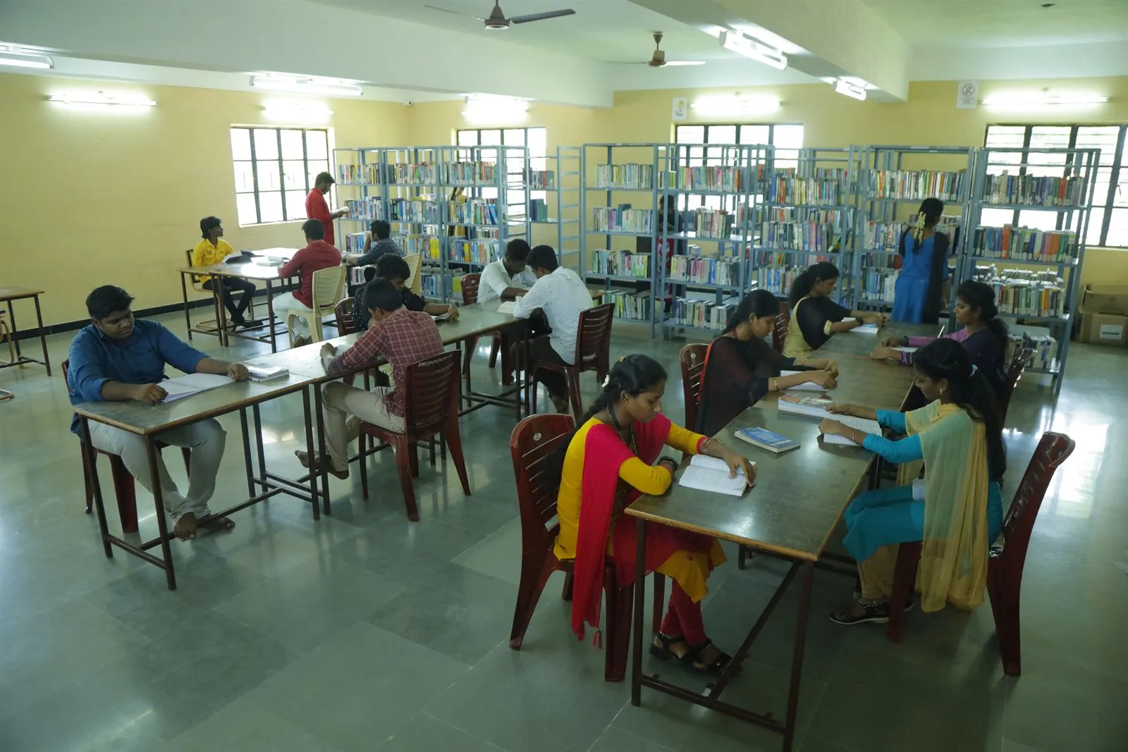 Students reading at tables in the college library